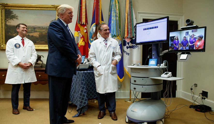 FILE - In this Aug. 3, 2017, file photo, Veterans Affairs Secretary David Shulkin, right, and White House physician Dr. Ronny Jackson, left, watch as President Donald Trump talks with a patient during a Veterans Affairs Department &amp;quot;telehealth&amp;quot; event in the Roosevelt Room of the White House in Washington. (AP Photo/Evan Vucci, File)