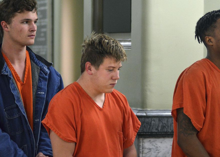 Nineteen-year-old Nathan Derickson, center, is led in to Vigo Superior Court's Division 5 courtroom on Thursday, March 29, 2018, in Terre Haute, Ind., for his initial hearing in the reckless homicide case that stemmed from a Wednesday morning shooting in Idle Creek subdivision in southeastern Vigo County. (Austen Leake/The Tribune-Star via AP)