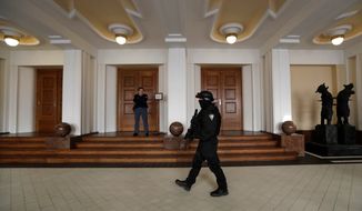 In this Friday, Nov. 24, 2017, file photo, a prison guard walks outside a courtroom during an appeal by Yevgeniy Nikulin from Russia who faces charges of hacking computers of American companies, in Prague, Czech Republic. The Czech Republic extradited a Russian man to the U.S. to face charges of hacking computers at LinkedIn, Dropbox and other American companies, an official said Friday, March 30, 2018. Nikulin was flown to the U.S. overnight, Justice Ministry spokeswoman Tereza Schejbalova said. (AP Photo/Petr David Josek)