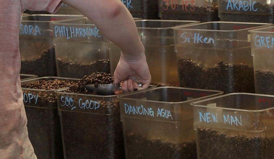 Adam Lange scoops coffee beans before making a drink at a Philz Coffee shop in San Francisco, Friday, March 30, 2018. Coffee sellers will have to post ominous warnings in California because each cup contains a chemical linked to cancer, a judge ruled. The culprit is a byproduct of the bean roasting process that is a known carcinogen and has been at the heart of an eight-year legal struggle between a tiny nonprofit group and Big Coffee companies. (AP Photo/Jeff Chiu)
