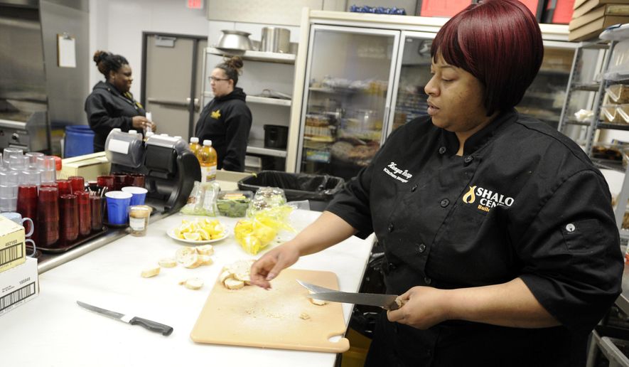 In this Saturday, March 24, 2018 photo, Kitchen Manager Kenya Reap works behind the scenes as the Shalom Center celebrates its 35th year serving meals in Kenosha, Wis. (Sean Krajacic /The Kenosha News via AP)