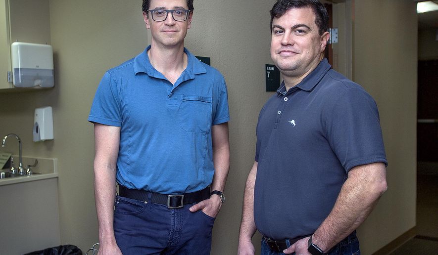 In this March 23, 2018 photo, Dr. Alonso Pacheco, left, and Dr. Travis Archuleta pose for a photo in Pueblo, Colo. They have prescribed the aid-in-dying medication. (John Jaques/The Pueblo Chieftain via AP)