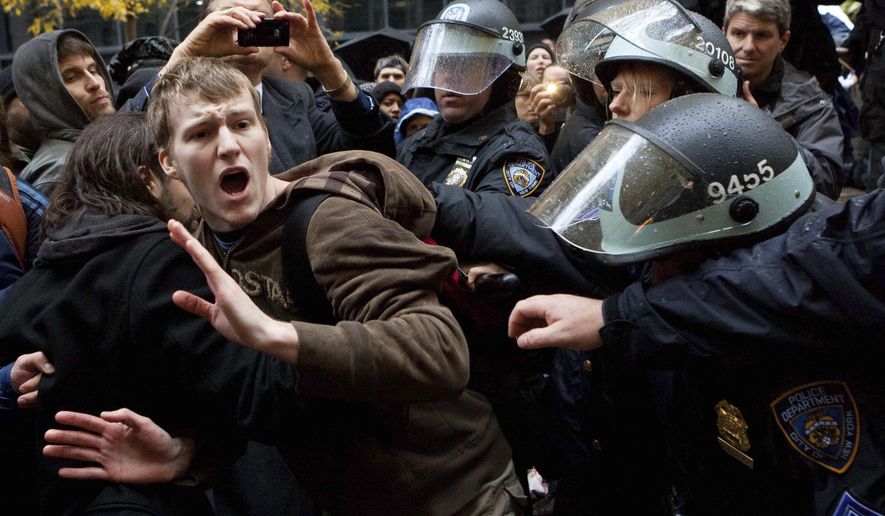 FILE - In this Thursday, Nov. 17, 2011 file photo, an Occupy Wall Street protestor is grabbed by police as he tries to escape a scuffle in Zuccotti Park in New York. (AP Photo/John Minchillo)