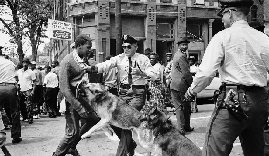 FILE - In this May 3, 1963 file photo, a 17-year-old civil rights demonstrator, defying an anti-parade ordinance of Birmingham, Ala., is attacked by a police dog. On the afternoon of May 4, 1963, during a meeting at the White House with members of a political group, President Kennedy discussed this photo, which had appeared on the front page of that day's New York Times. (AP Photo/Bill Hudson, File)