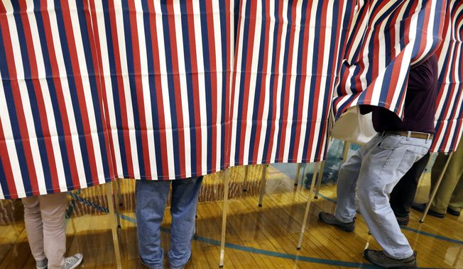 In this Nov. 8, 2016, file photo, a voter enters a booth at a polling place in Exeter, N.H. (AP Photo/Elise Amendola, File)