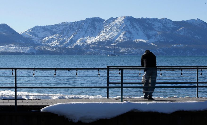 File - In this March 5, 2018 file photo, snow covers the mountain tops over looking Lake Tahoe in South Lake Tahoe, Calif. Californians close out their rainy season with the break they were hoping for, as a series of late-winter storms ease drought conditions that had been setting in again. (AP Photo/Rich Pedroncelli, File)