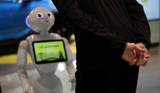 In this photo dated March 12, 2018, a guests asks robot Robby Pepper for information at the front desk of hotel in Peschiera del Garda, northern Italy. Robby Pepper, billed as Italy&#x27;s first robot concierge, has been programed to answer simple guest questions in Italian, English and German, the humanoid, speaking robot will be deployed all season at a hotel on the popular Garda Lake to help relieve the desk staff of simple, repetitive questions. (AP Photo/Luca Bruno) ** FILE **