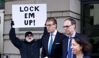 Alex van der Zwaan leaves Federal District Court in Washington, Tuesday, April 3, 2018. Holding the sign up is Bill Christeson from the Washington area. A federal judge sentenced Alex van der Zwaan to 30 days in prison. (AP Photo/Pablo Martinez Monsivais)