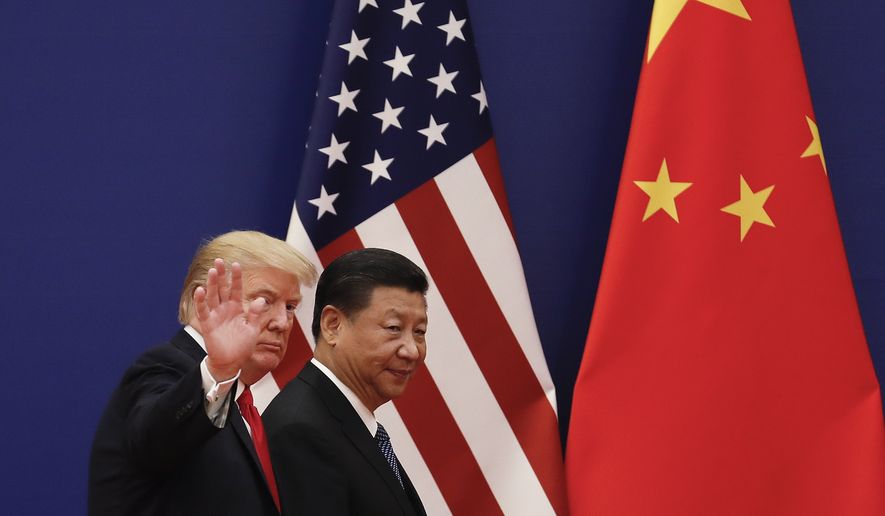 U.S. President Donald Trump waves next to Chinese President Xi Jinping after attending a business event at the Great Hall of the People in Beijing, Thursday, Nov. 9, 2017. Trump is on a five-country trip through Asia traveling to Japan, South Korea, China, Vietnam and the Philippines. (AP Photo/Andy Wong)