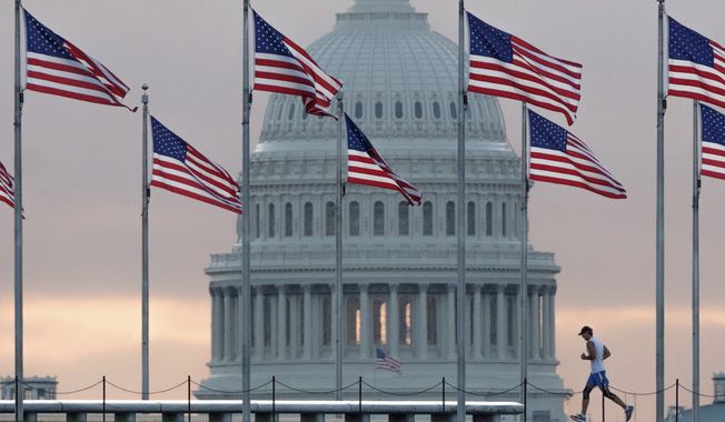 In this Sept. 27, 2017, photo, a early morning runner crosses in front of the U.S. Capitol as he passes the flags circling the Washington Monument in Washington. Congress is considering letting President Donald Trump roll back some of the $1.3 trillion federal spending package as Republicans in the House and Senate get hammered politically by conservatives for having approved the big spending bill. Rolling back the funds would be a highly unusual move and could put some lawmakers in the potentially uncomfortable position of having to vote for specific spending opposed by a president from their party. It would also offer Republicans a way to save face. (AP Photo/J. David Ake, File)