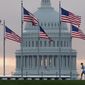In this Sept. 27, 2017, photo, a early morning runner crosses in front of the U.S. Capitol as he passes the flags circling the Washington Monument in Washington. Congress is considering letting President Donald Trump roll back some of the $1.3 trillion federal spending package as Republicans in the House and Senate get hammered politically by conservatives for having approved the big spending bill. Rolling back the funds would be a highly unusual move and could put some lawmakers in the potentially uncomfortable position of having to vote for specific spending opposed by a president from their party. It would also offer Republicans a way to save face. (AP Photo/J. David Ake, File)