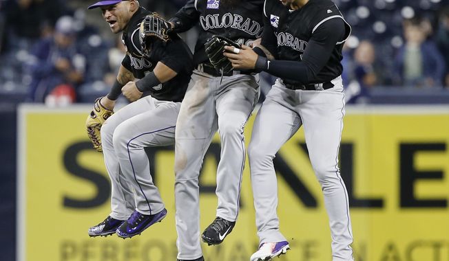 Colorado Rockies outfield, Gerardo Parra, left, Charlie Blackmon, center, and Carlos Gonzalez leap in celebration of the Rockies defeating the San Diego Padres 7-4 after the ninth inning of a baseball game in San Diego, Monday, April 2, 2018. (AP Photo/Alex Gallardo)