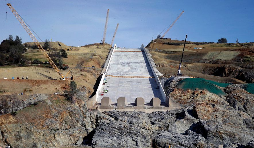 FILE--In this Nov. 30, 2017, file photo, work continues on the Oroville Dam spillway, in Oroville, Calif. California water officials say they may have to use the partially rebuilt spillway at Oroville Dam for the first time since they began repairs to the badly damaged structure last summer. Department of Water Resources officials said Tuesday, April 3, 2018, that anticipated storms could send trigger releases this week or next. (AP Photo/Rich Pedroncelli, file)