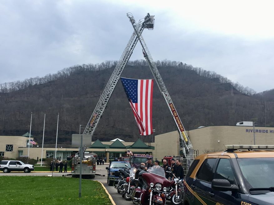 Fire ladder trucks are shown outside Riverside High School during the funeral for Pratt Volunteer Fire Department Lt. Tom Craigo in Belle, W.Va., Tuesday, April 3, 2018. Services have been held for the West Virginia firefighter whose firetruck slammed into a rock wall while responding to a fatal accident. (AP Photo/John Raby)