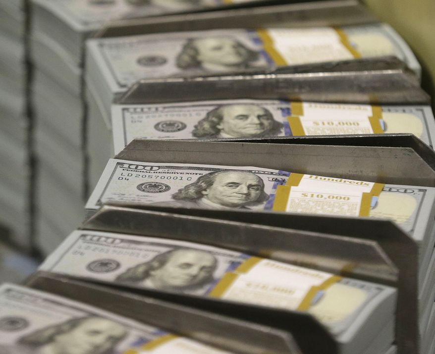 In this Sept. 24, 2013, file photo, cut stacks of $100 bills make their way down the line at the Bureau of Engraving and Printing Western Currency Facility in Fort Worth, Texas. (AP Photo/LM Otero) ** FILE **