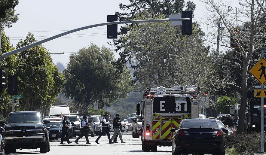 Officers walk near a YouTube office in San Bruno, Calif., Tuesday, April 3, 2018. Police in Northern California are responding to reports of a shooting at YouTube headquarters in the city of San Bruno. (AP Photo/Jeff Chiu)