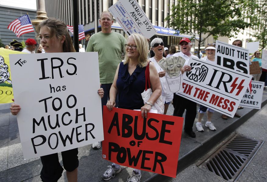 In this May 21, 2013, file photo, tea party activists demonstrate on Fountain Square before marching to the John Weld Peck Federal Building in Cincinnati to protest the Internal Revenue Service's targeting of conservative groups seeking tax-exempt status. On Wednesday, April 4, 2018, a federal judge gave preliminary approval to a $3.5 million settlement of a lawsuit against the IRS over alleged targeting of tea party and other groups. (AP Photo/Al Behrman, File)