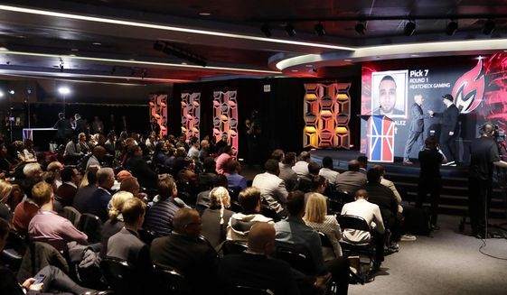 People watch the NBA 2K League draft Wednesday, April 4, 2018, in New York. Launching in 2018, the league will feature the best NBA 2K players in the world and will draft players to compete as unique characters in 5-on-5 play against the other teams in a mix of regular-season games, tournaments and playoffs. (AP Photo/Frank Franklin II) **FILE**