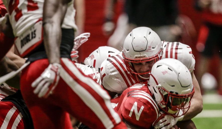 In this April 3, 2018, photo, Nebraska running back Mikale Wilbon, bottom right, is tackled during spring training in Lincoln, Neb. Unlike the trend in the sport of less contact in practices instead of more, Nebraska head coach Scott Frost wants Huskers' practices to be physical to toughen up his team. (AP Photo/Nati Harnik)
