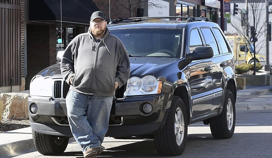 In this March 29, 2018, photo, Kevin Webster of Night Owl Sober Driving Service stands near his vehicle in downtown Mankato, Minn. Webster and his partner Ryan Hood drive people home in their vehicle when they've had too much to drink. (Pat Christman/The Free Press via AP)