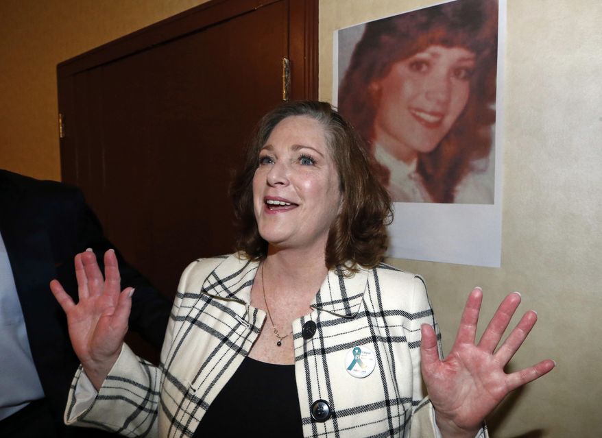 McKenna Denson stands next to her portrait following a news conference Thursday, April 5, 2018, in Salt Lake City. Denson, who accused a former Mormon missionary training center director of raping her in the 1980s and the church of failing to take her allegations seriously, has sued the man and the church in a move that could bring more scrutiny to the religion's handling of sexual abuse reports. (AP Photo/Rick Bowmer)
