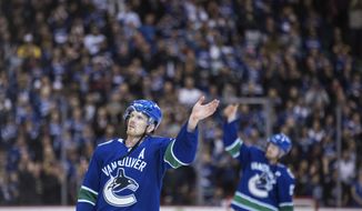 Vancouver Canucks&#39; Daniel Sedin, left, and his twin brother, Henrik Sedin wave to the crowd after the Canucks defeated the Arizona Coyotes 4-3 in the Sedins&#39; final home NHL hockey game, Thursday, April 5, 2018, in Vancouver, British Columbia. (Darryl Dyck//The Canadian Press via AP)