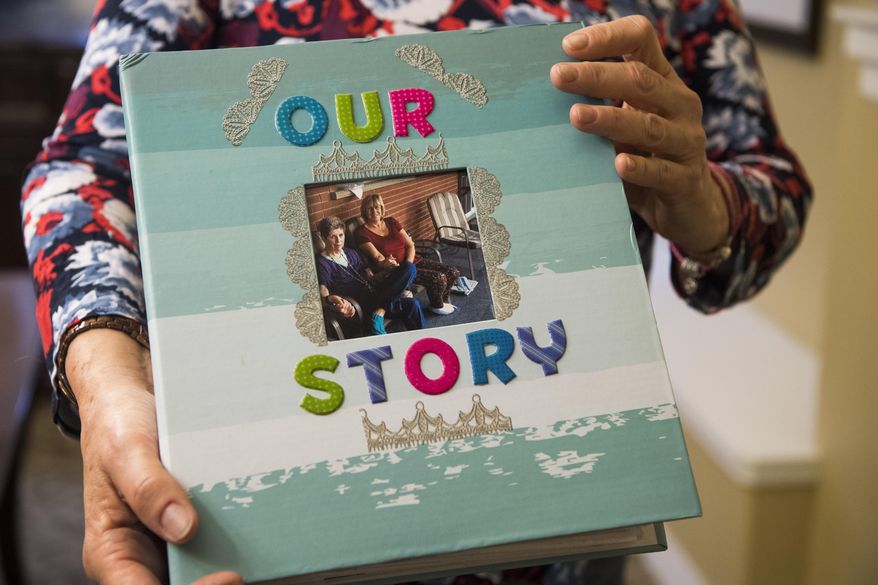 In this March 16, 2018 photo, Kathy Kirkland holds a scrapbook she made from her mother, Joan Harrison, at Brookdale retirement home in Ogden, utah. Harrison gave Kirkland up for adoption 60 years ago, and Kirkland made contact with her last year (James M. Dobson/The Spectrum via AP)
