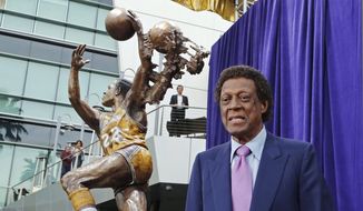 Elgin Baylor stands next to a statue, just unveiled, honoring the Minneapolis and Los Angeles Lakers great, outside Staples Center in Los Angeles on Friday, April 6, 2018. (AP Photo/Reed Saxon) **FILE**