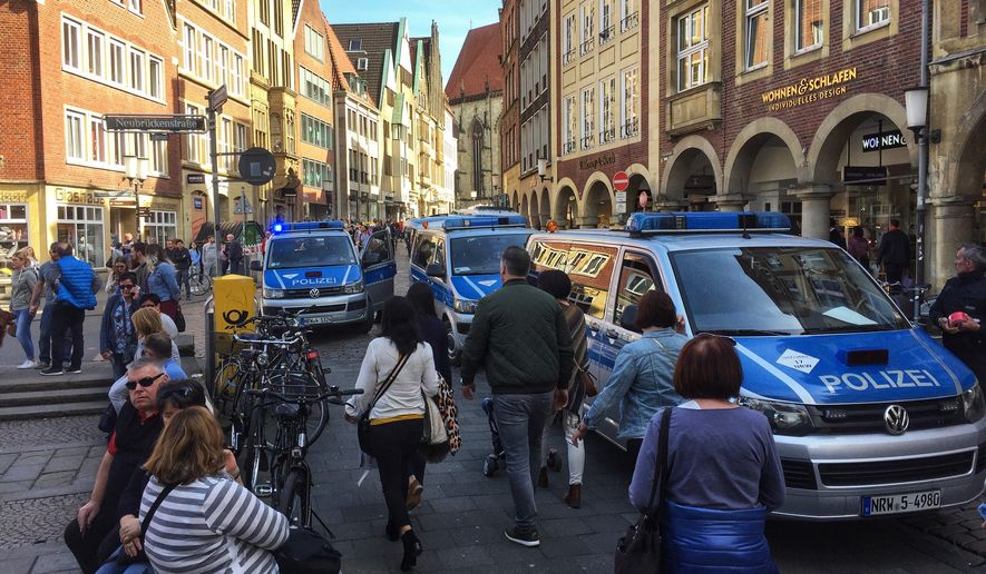 Police vans stand in downtown Muenster, Germany, Saturday, April 7, 2018. German news agency dpa says several people killed after car crashes into crowd in city of Muenster.  (dpa via AP)