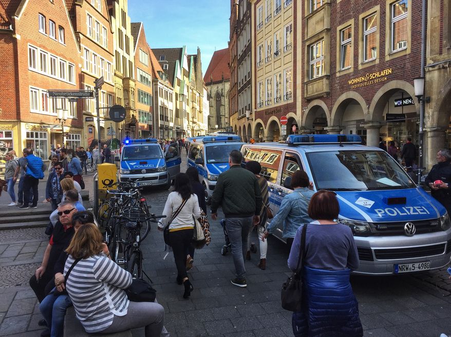 Police vans stand in downtown Muenster, Germany, Saturday, April 7, 2018. German news agency dpa says several people killed after car crashes into crowd in city of Muenster.  (dpa via AP)