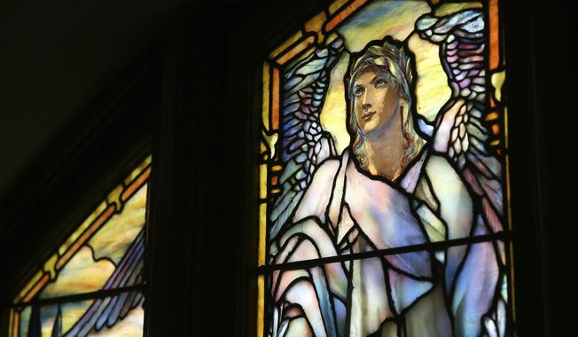 In this Monday, March 26, 2018 photo, sunlight illuminates a section of The Angel of Resurrection stained glass window by American artist Louis Tiffany at The Church of the Advent in Cincinnati. The church features stained glass by American artist Louis Tiffany. (Kareem Elgazzar/The Cincinnati Enquirer via AP)