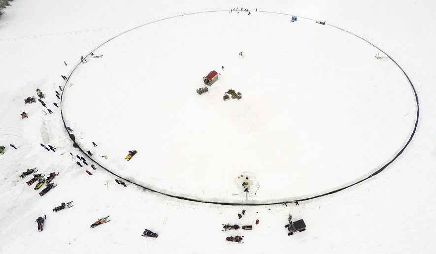 This photo provided by Paul Cyr shows a massive ice carousel that's 427 feet in diameter on Saturday, April 7, 2018, on a frozen lake in Sinclair, Maine. Volunteers say it’s large enough to beat the old record held by a town in Finland; four outboard engines were used to make it rotate. (AP Photo/Paul Cyr)