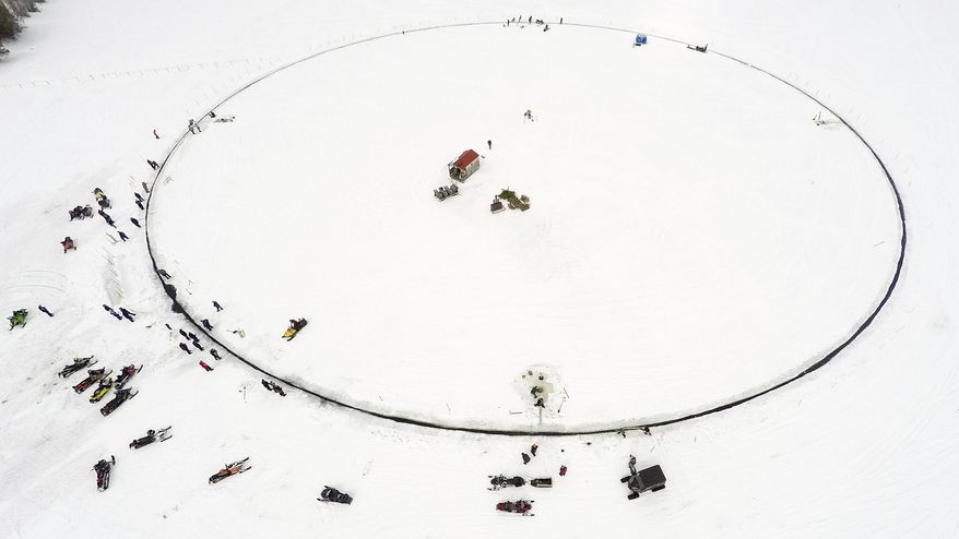 This photo provided by Paul Cyr shows a massive ice carousel that's 427 feet in diameter on Saturday, April 7, 2018, on a frozen lake in Sinclair, Maine. Volunteers say it’s large enough to beat the old record held by a town in Finland; four outboard engines were used to make it rotate. (AP Photo/Paul Cyr)