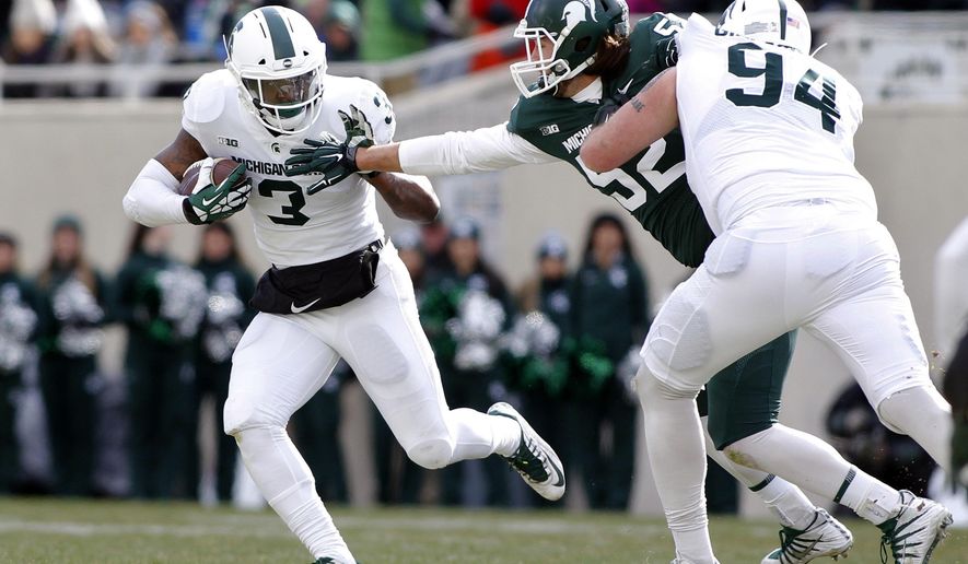 Michigan State running back LJ Scott, left, rushes against defensive end Dillon Alexander as offensive lineman Chase Gianacakos (94) blocks during the first half of a spring NCAA college football scrimmage, Saturday, April 7, 2018, in East Lansing, Mich. (AP Photo/Al Goldis)