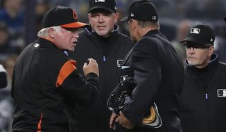 Baltimore Orioles manager Buck Showalter, left, argues with umpires about a call on a rundown involving New York Yankees&#39; Giancarlo Stanton and Gary Sanchez during the sixth inning of a baseball game Friday, April 6, 2018, in New York. While Showalter argued they were both out on the play, the umpires ruled Stanton out at home and Sanchez safe at third base. (AP Photo/Julie Jacobson)