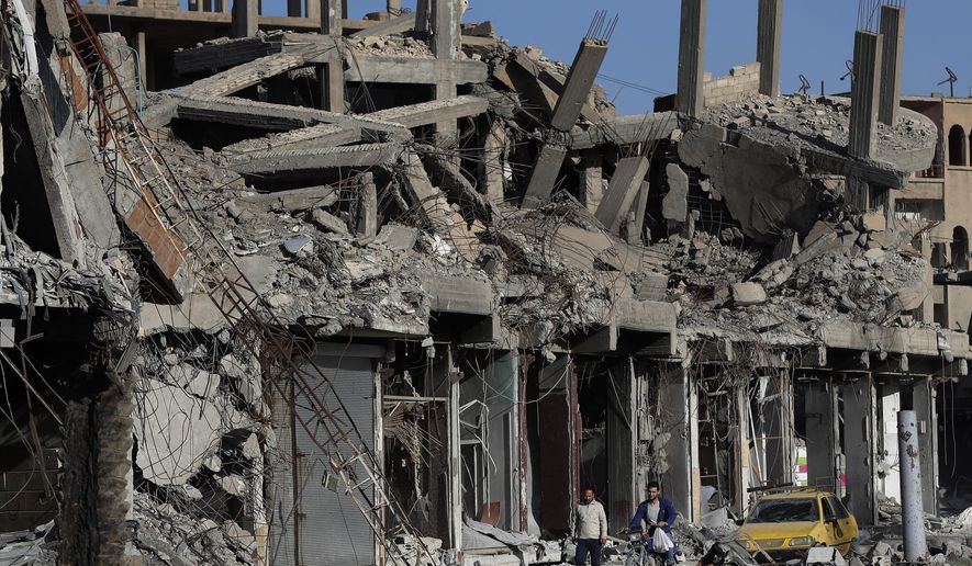 In this Thursday, April 5, 2018, photo, destroyed buildings line a street that was damaged during fighting between U.S.-backed Syrian Democratic Forces fighters and Islamic State militants, in Raqqa, Syria. (AP Photo/Hussein Malla) ** FILE **