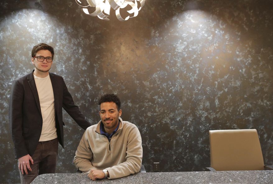 In this March 22, 2018 photo, Jacob Melin, left, and Enrique Rodriquez, two college dropouts who have scored big with bitcoin and have started their own company Crypto Consulting Group, pose in Louisville, Ky. (Pat McDonogh/Courier Journal via AP)