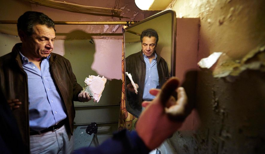 FILE - In this March 12, 2018 file photo, New York Gov. Andrew Cuomo examines a damaged piece of a bathroom wall in a New York City Housing Authority (NYCHA) apartment during a tour of the Andrew Jackson Houses in the Bronx borough of New York. Cuomo recently declared a state of emergency at the New York City Housing Authority and said he would set up an independent monitor to oversee repairs after federal housing secretary Ben Carson said he would require the agency to get prior approval from the Department of Housing and Urban Development for any expenditure out of its capital fund. (James Keivom/New York Daily News via AP, Pool, File)