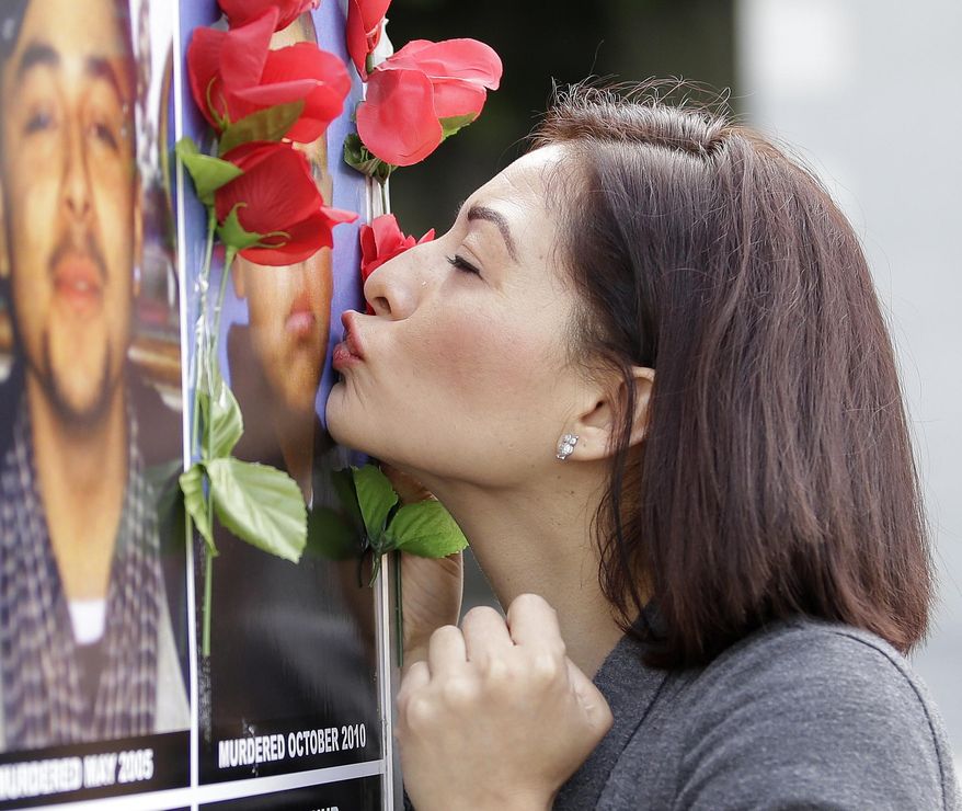 Teresa Hernandez kisses a photo of her late son, Alonso Morales-Hernandez, at a victims rights rally Monday, April 9, 2018, in Sacramento, Calif. Morales-Hernandez, 14, was shot and killed in 2010 as he was walking home from school in Salinas. Voters this year may decide whether to roll back portions of two ballot measures passed, in 2014 and 2016, that criminal justice groups say impede investigations and free violent offenders too soon. On the opposite side reform groups want to further scale back what was one the nation's toughness law targeting repeat offenders. (AP Photo/Rich Pedroncelli)