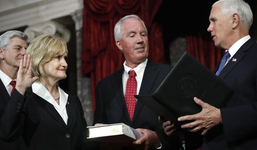 Mississippi Republican Cindy Hyde-Smith, left, is welcomed as the newest member of the U.S. Senate by Vice President Mike Pence, right, as she is joined by her husband, Michael Smith, center, and Mississippi Gov. Phil Bryant, far left, during a ceremonial swearing-in at the Old Senate Chamber, Monday, April 9, 2018, in the Capitol in Washington. She was appointed by Mississippi Gov. Bryant to succeed Sen. Thad Cochran, R-Miss., who resigned in April for health reasons. (AP Photo/Jacquelyn Martin)
