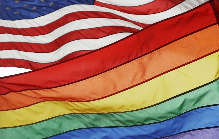 The Rainbow Flag flies beneath the American flag at the Stonewall National Monument, Wednesday, Oct. 11, 2017, in New York. The Rainbow Flag, an international symbol of LGBT liberation and pride, was flown for the first time at the monument. (AP Photo/Mark Lennihan)