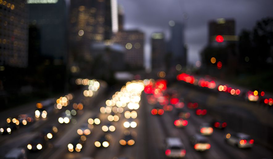 In this defocused image, traffic moves along the 110 Freeway, Wednesday, Dec. 20, 2017, in downtown Los Angeles. Thursday will be the season's busiest traffic day in the United States, according to AAA forecasts. (AP Photo/Jae C. Hong)