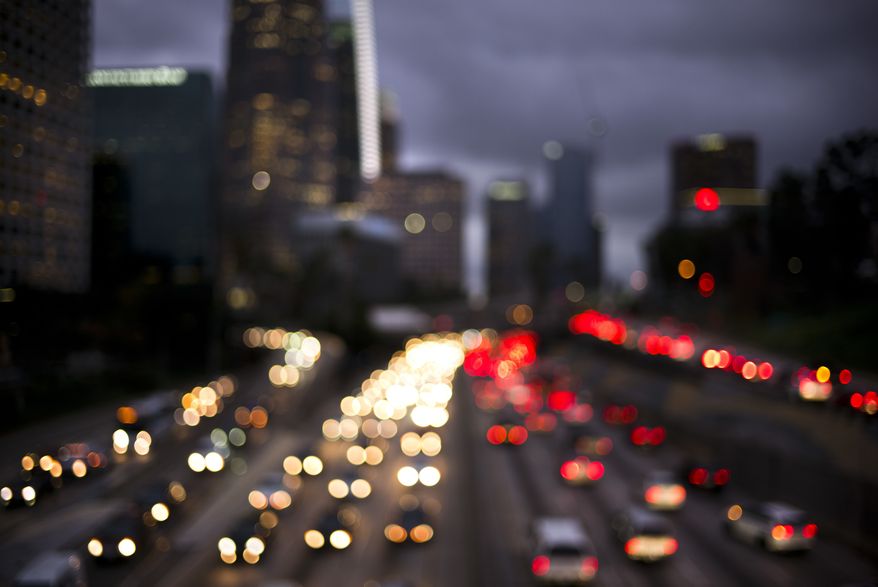 In this defocused image, traffic moves along the 110 Freeway, Wednesday, Dec. 20, 2017, in downtown Los Angeles. Thursday will be the season's busiest traffic day in the United States, according to AAA forecasts. (AP Photo/Jae C. Hong)