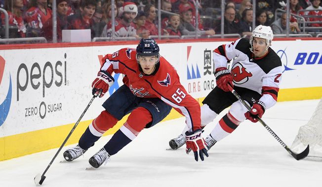 Washington Capitals left wing Andre Burakovsky (65) skates with the puck against New Jersey Devils defenseman John Moore (2) during the second period of an NHL hockey game, Saturday, April 7, 2018, in Washington. (AP Photo/Nick Wass) ** FILE **