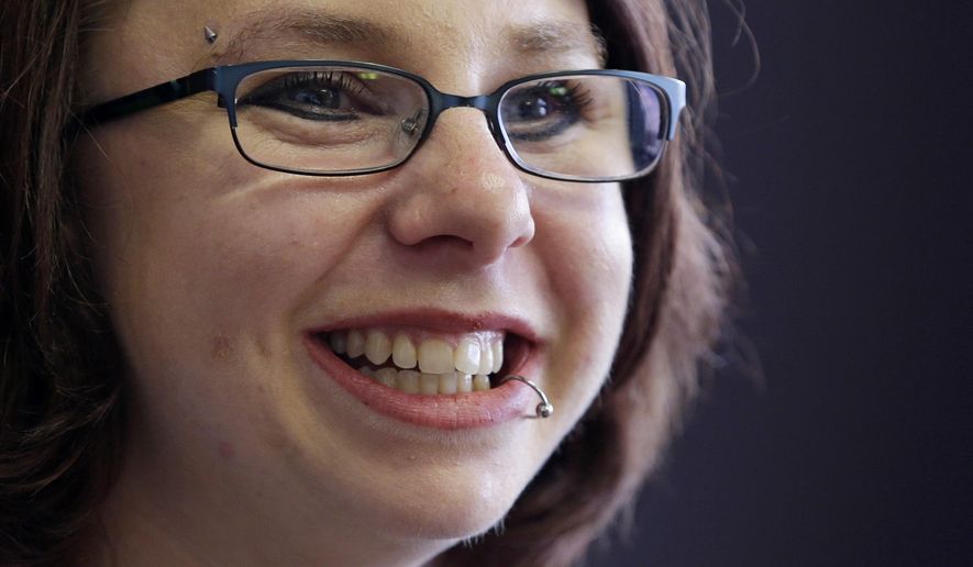 FILE - In this June 26, 2014, file photo, Michelle Knight smiles during an interview in Cleveland. Knight , one of three women who escaped a Cleveland home after being held for a decade has revealed she’s married. Knight announced on “Dr. Phil” that she has been happily married since May 2016. The episode, in which she promotes her book, “Life After Darkness,” is scheduled to air April 24, 2018. (AP Photo/Tony Dejak, File)