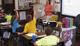 In this Sept. 18, 2013, photo, Shelly Ellis teaches fourth-grade students in a newly air conditioned classroom at Bement Elementary School in Bement, Ill. (AP Photo/David Mercer, File)