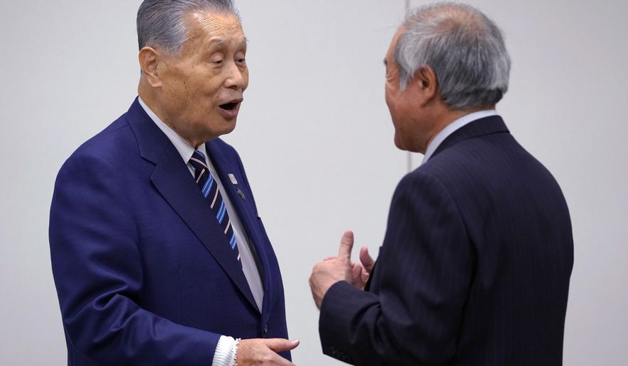 Tokyo 2020 Olympics President Yoshiro Mori, left, talks with Shunichi Suzuki, minister of the Tokyo 2020 Olympic and Paralympic Games, during an executive board meeting in Tokyo, Tuesday, April 10, 2018. Tokyo Olympic organizers said the Olympic flame will be put on display at various locations in the Tohoku region to help underscore Japan&#x27;s recovery from the disaster that took more than 18,000 lives and triggered meltdowns at the Fukushima nuclear power plant. (AP Photo/Shizuo Kambayashi)