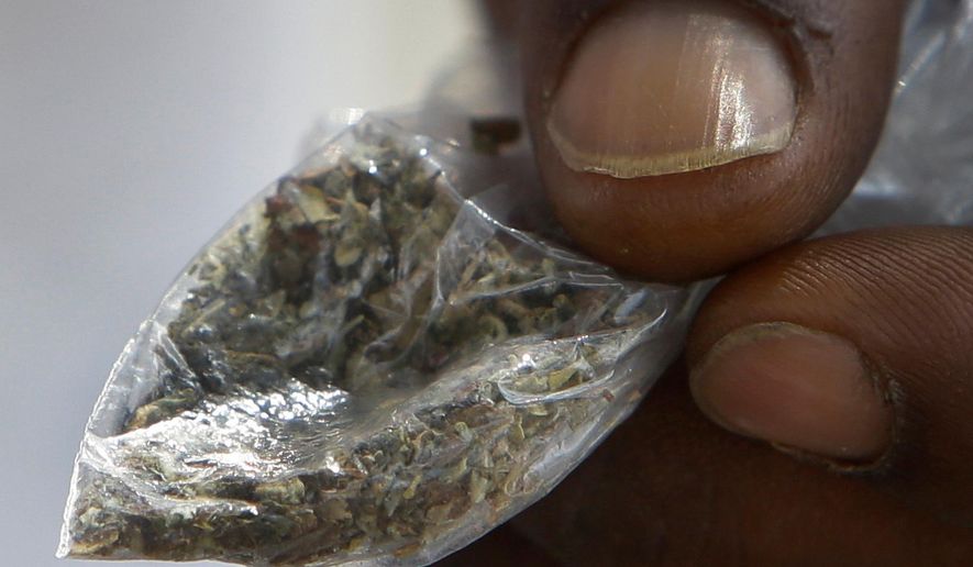 FILE - In this June 29, 2016 file photo, a man holds a bag of synthetic marijuana in Houston. In a report released Tuesday, April 10, 2018, fake marijuana likely contaminated with rat poison has killed three people in Illinois and sickened more than 100 others in the past month. (Melissa Phillip/Houston Chronicle via AP)