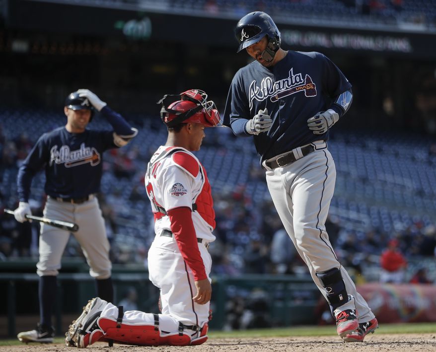 Atlanta Braves Kurt Suzuki (24) crosses home as Washington Nationals catcher Pedro Severino (29) watches, after hitting a solo homer in the 11th inning of a baseball game at Nationals Park, Wednesday, April 11, 2018 in Washington. Waiting on the on-deck circle is Braves Peter Bourjos (12), Atlanta won 5-3. (AP Photo/Pablo Martinez Monsivais)