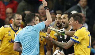 Referee Michael Oliver shows a red car to Juventus goalkeeper Gianluigi Buffon during a Champions League quarter final second leg soccer match between Real Madrid and Juventus at the Santiago Bernabeu stadium in Madrid, Wednesday, April 11, 2018. (AP Photo/Francisco Seco)